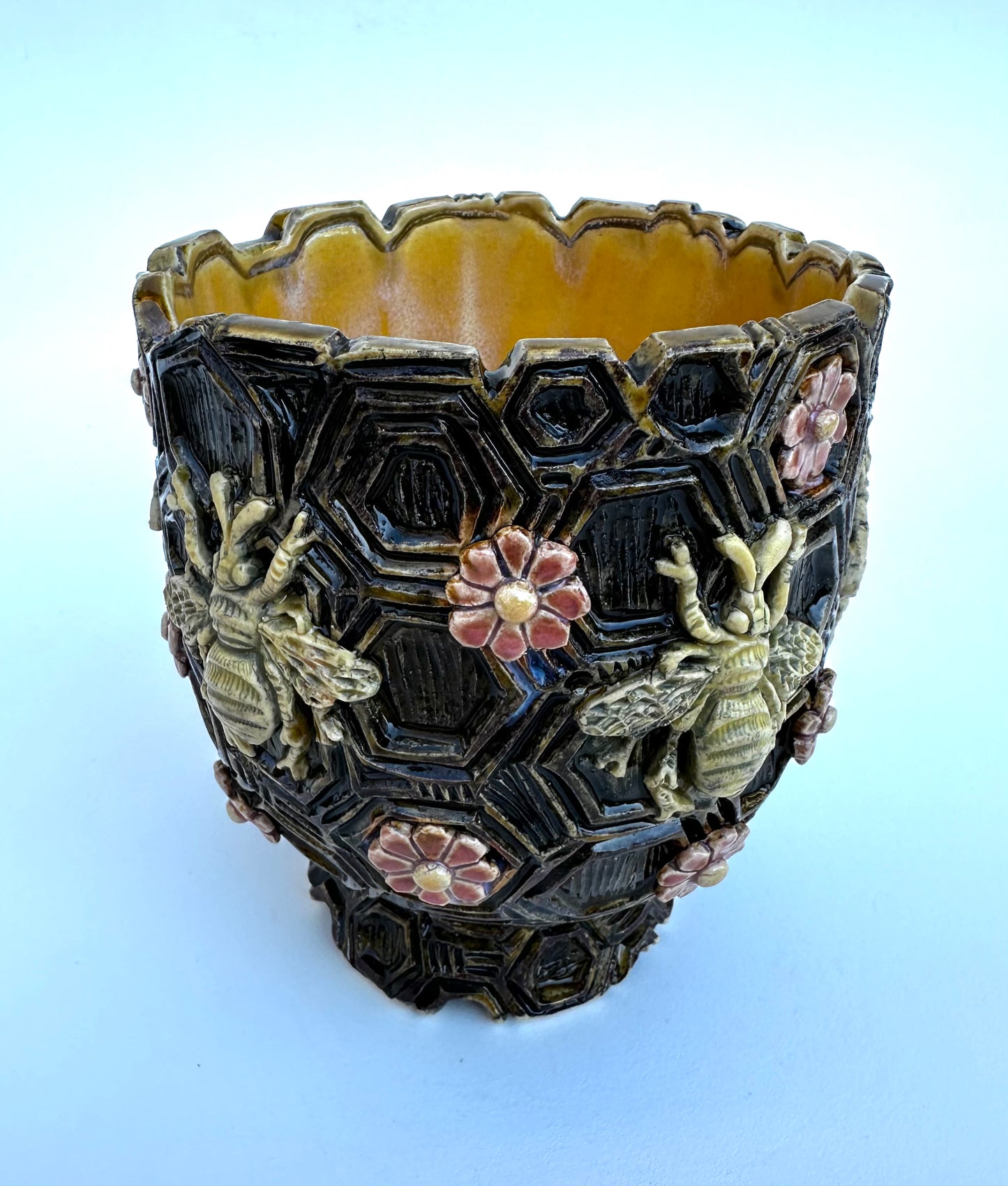Bowl with honeybees and daisies on honeycombs